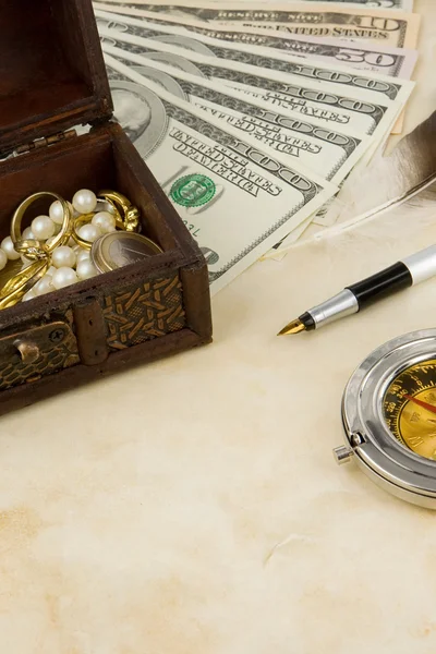 Доллары, компас, коробка и монеты по текстуре — стоковое фото