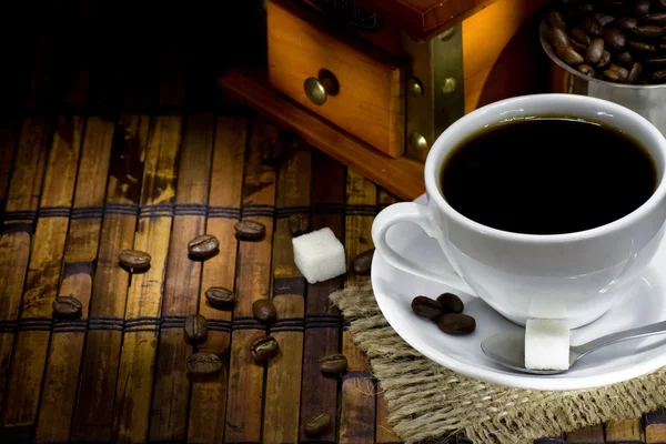 Granos de café y molinillo en el saqueo en la noche — Foto de Stock