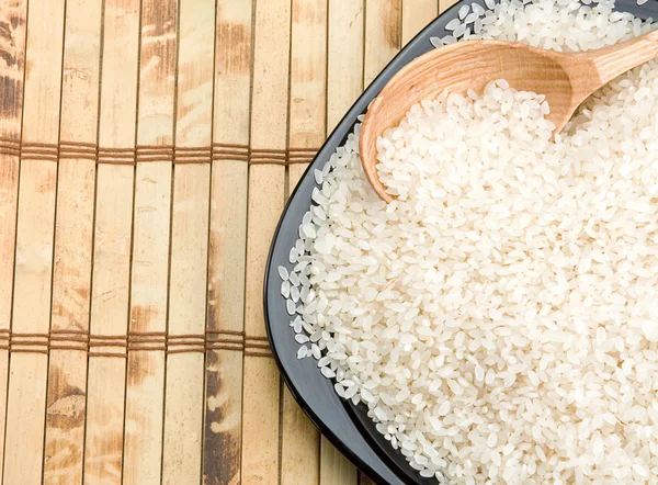 Rice and wood plate with spoon — Stock Photo, Image