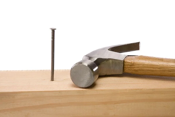 Hamer en nagel geïsoleerd op hout baksteen op wit — Stockfoto