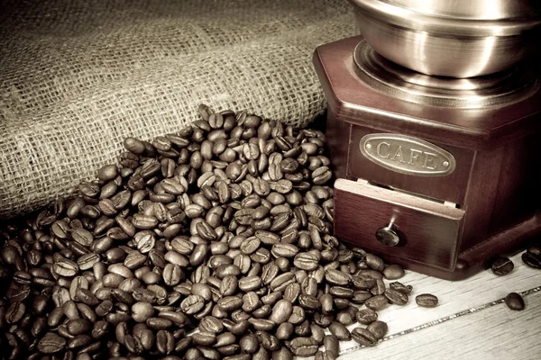 Coffee beans and grinder on sacking in night — Stock Photo, Image