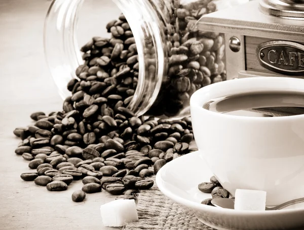 Cup of coffee and beans on sepia — Stock Photo, Image