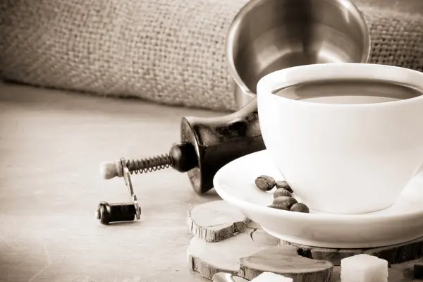 Kopje koffie en grinder met bonen — Stockfoto