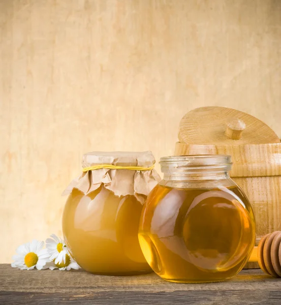 Glass jar of honey and stick — Stock Photo, Image