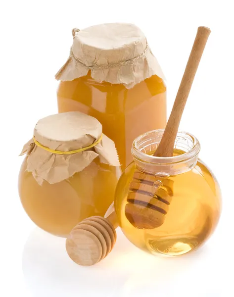 Frasco de vidro cheio de mel e pau — Fotografia de Stock