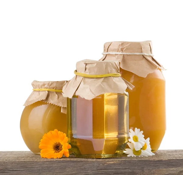 Honey and flowers isolated on white — Stock Photo, Image