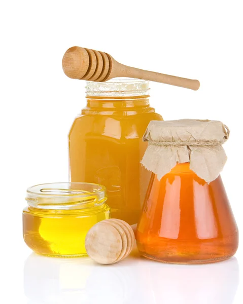 Bocal en verre plein de miel et bâton — Photo