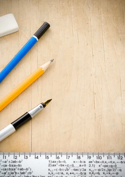 Ручка, карандаш и линейка на дереве — стоковое фото