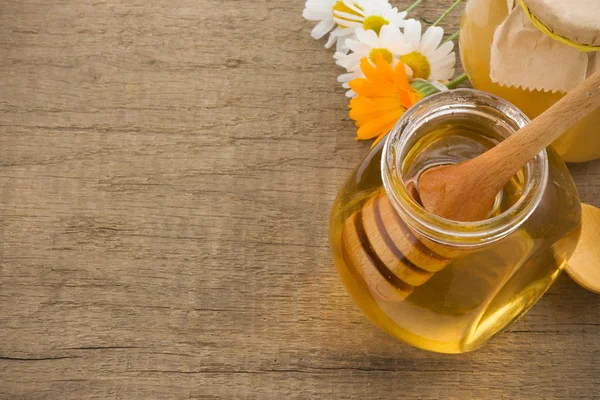 Jar of honey and flowers — Stock Photo, Image