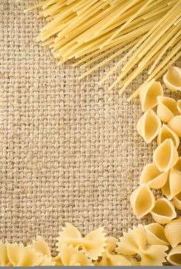 Raw pasta on sack burlap clipart