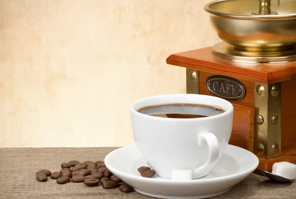 Cup of coffee with beans and grinder — Stock Photo, Image