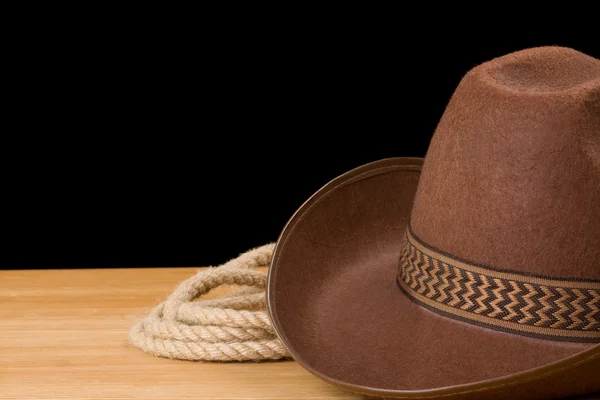 Kovbojský klobouk a provaz, izolované na černém pozadí — Stock fotografie