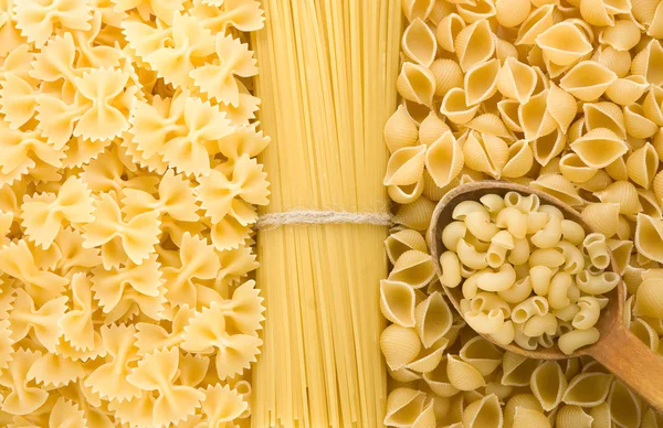 Ruwe pasta en houten lepel — Stockfoto