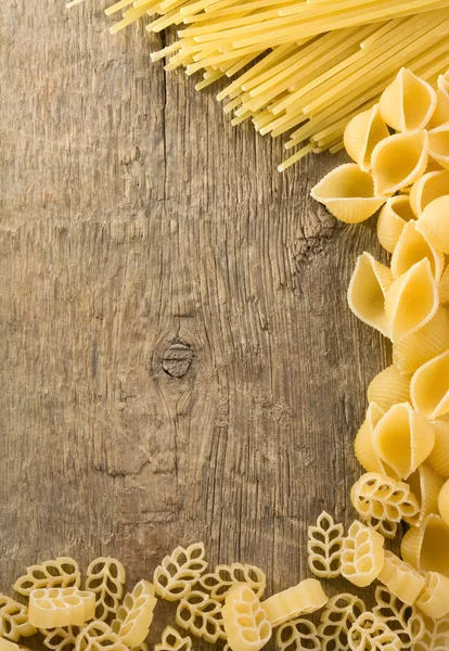 Rå pasta på trä bakgrund — Stockfoto