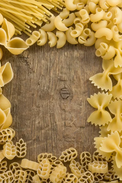 Pasta cruda su fondo legno — Foto Stock