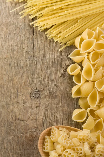 Raw pasta on wood background — Stock Photo, Image