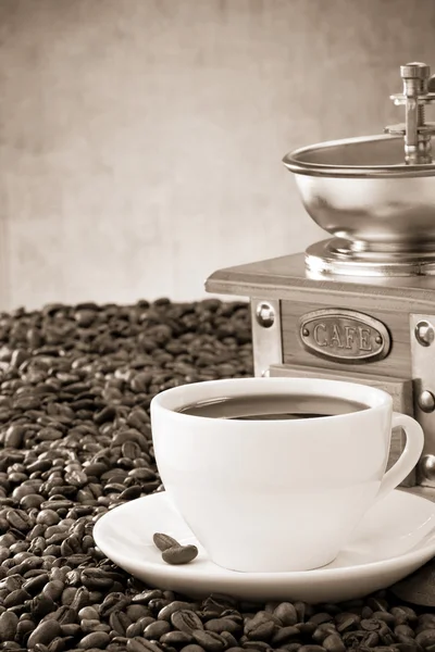 Cup of coffee and grinder with beans — Stock Photo, Image