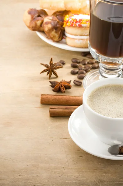 Xícara de café com feijão e bolos em madeira — Fotografia de Stock