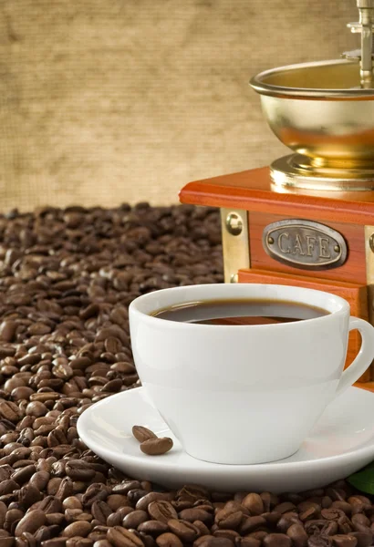 Tasse Kaffee mit Bohnen auf Sack Hintergrund — Stockfoto