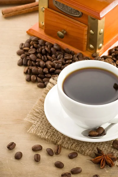 Cup of coffee and beans on wood — Stock Photo, Image