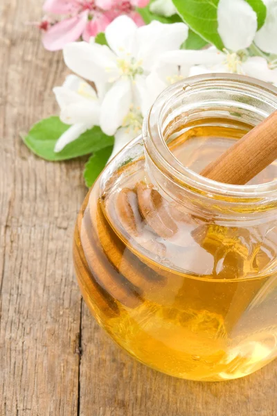 Honey in glass jar on wood — Stock Photo, Image
