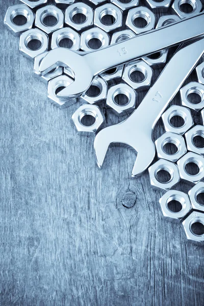 Metal nuts and wrench tool on wood background — Stock Photo, Image