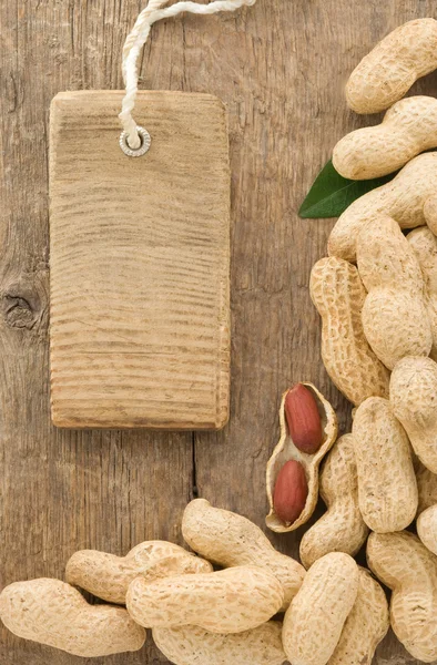 Орехи арахис фрукты и цена тега на фоне дерева — стоковое фото