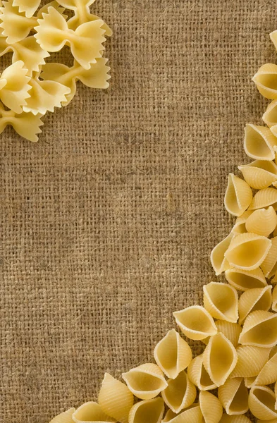 Ruwe pasta op zak achtergrond — Stockfoto