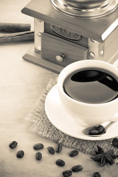 Φλιτζάνι καφέ για τους φρυγμένους κόκκους στο ξύλινο υπόβαθρο — Φωτογραφία Αρχείου