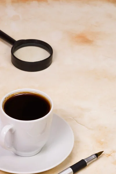Vergrootglas en kopje koffie — Stockfoto