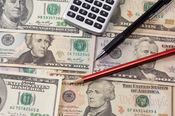Calculator, pens on dollars — Stock Photo, Image