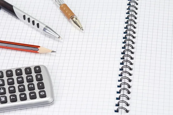 Calcolatrice, penne, matita su pad — Foto Stock
