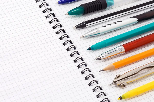 Ручки и карандаши на блокноте — стоковое фото