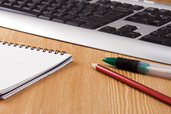 Прокладка, черная клавиатура и ручки — стоковое фото