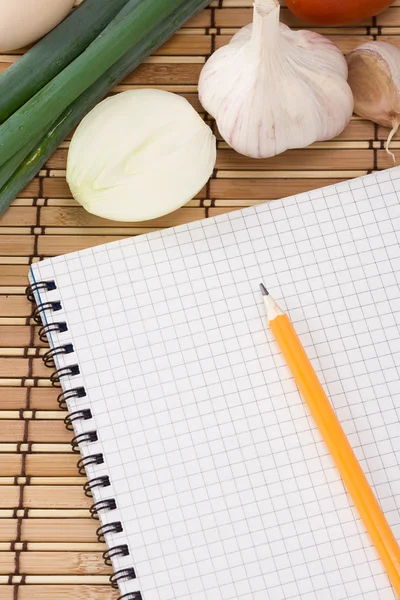 Zápisník, česnek a cibule — Stock fotografie