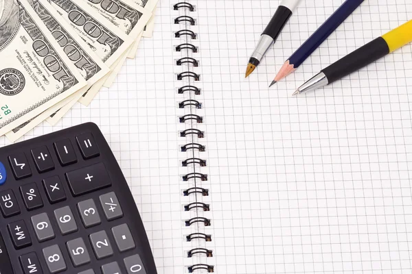 Bolígrafos, calculadora y dólares — Stockfoto
