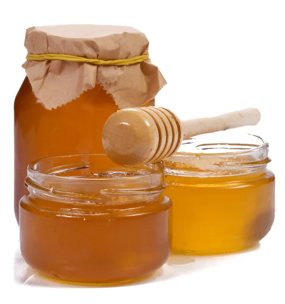 Tarro de vidrio lleno de miel y palo — Foto de Stock