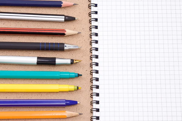 Ручки и карандаши с блокнотом — стоковое фото