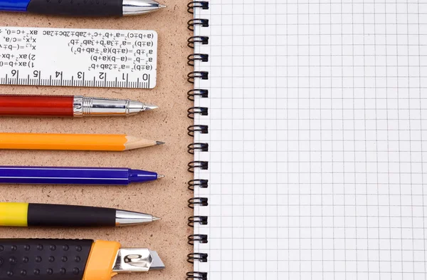 Pennen, potloden en pad op houttextuur — Stockfoto