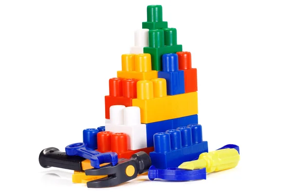 Brinquedos de plástico coloridos e tijolos — Fotografia de Stock