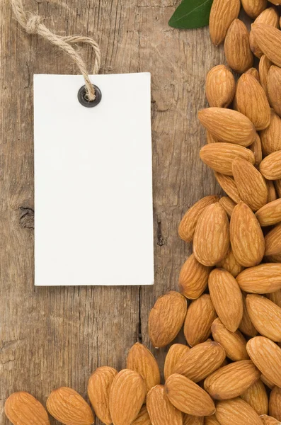 Ořechy mandle a tag cenových etiket na dřevo — Stock fotografie