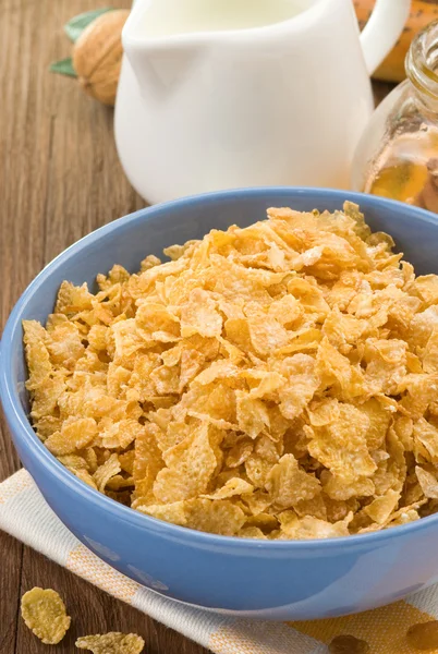 Bowl of corn flakes and milk on wood — Stock Photo, Image