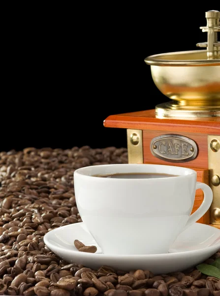 Xícara de café e moedor isolado em preto — Fotografia de Stock