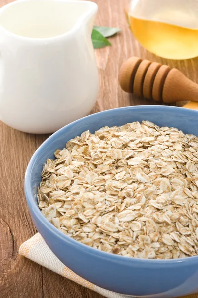 Bowl of oat and milk on wood — Stock Photo, Image
