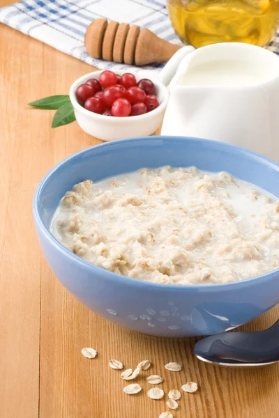 Oatmeal with milk and honey on wood — Stock Photo, Image