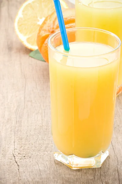 Suco de laranja de frutas frescas em vidro na tábua de madeira — Fotografia de Stock