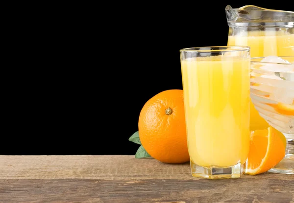 Suco e laranjas isolados em preto — Fotografia de Stock