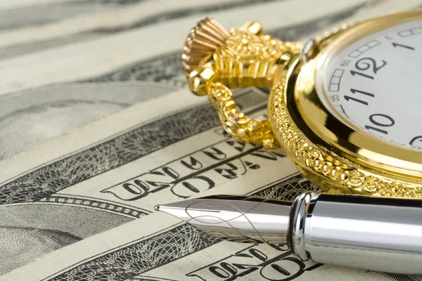 Inkt pen en horloge over dollar biljetten — Stockfoto