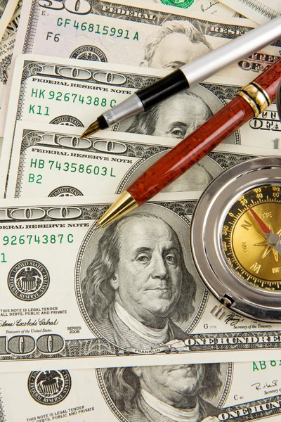 Pens and gold compass on dollars — Stock Photo, Image