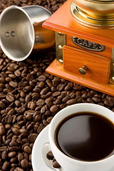 Чашка кофе, мясорубка и кастрюля на бобах — стоковое фото